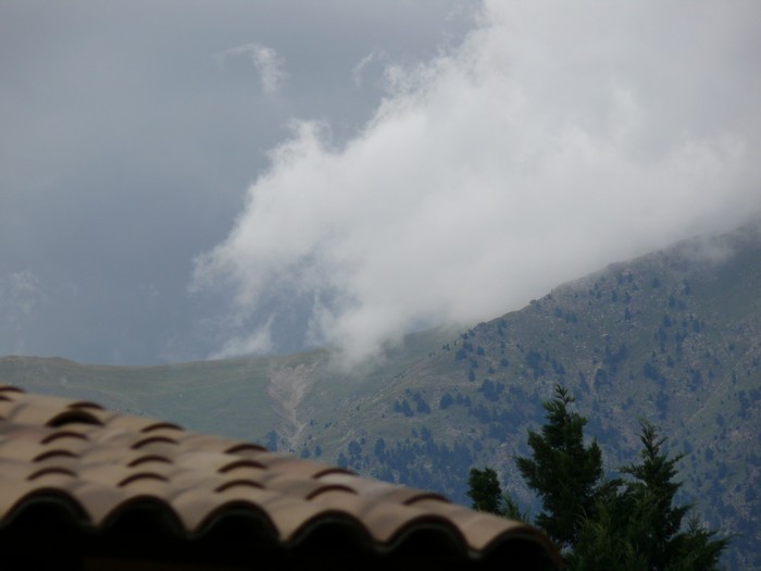 Een wolk sluiert over de bergen om Roquebilli&egrave;re.